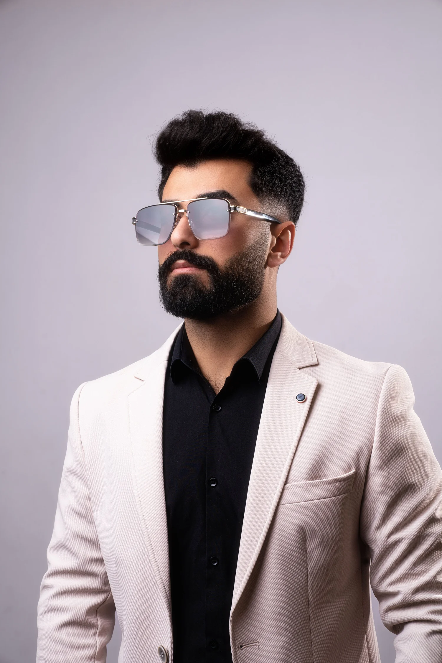 Mann mit Bart in weißer Jacke und Sonnenbrille